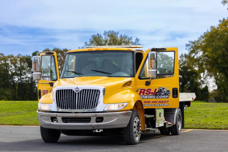 Yellow RSJ Towing flatbed truck with both doors open